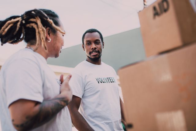 two people wearing volunteer shirts next to boxes