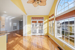Bright empty rental home with hardwood floors and large windows, representing the strategic opportunity available during a property turnover.