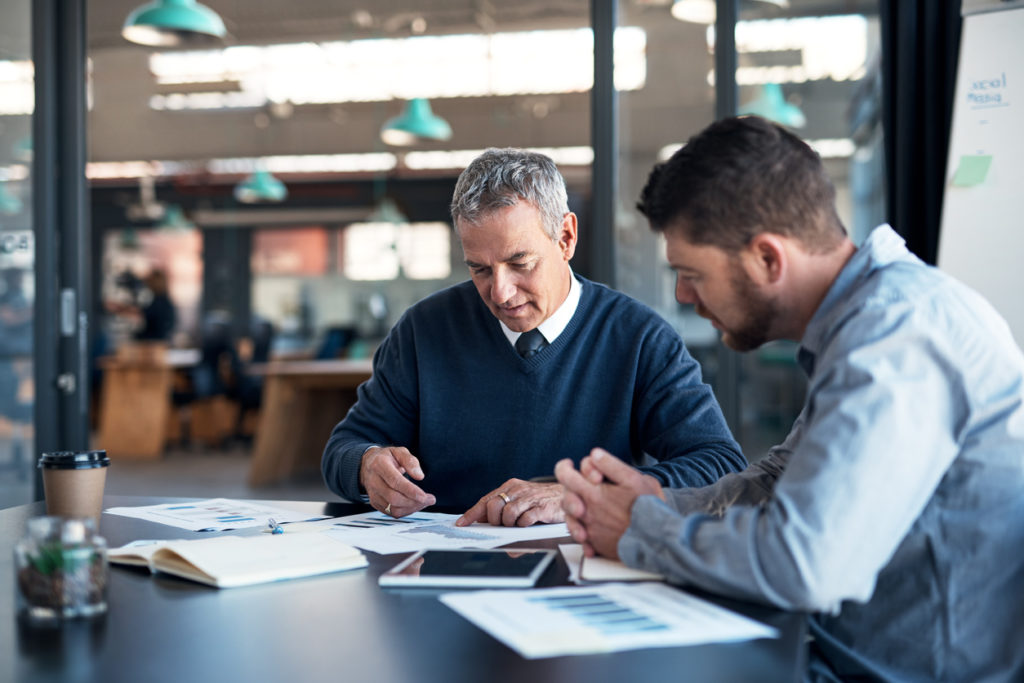 Shot of two businessmen going through paperwork together in an office