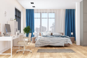 A room showcasing a well-arranged bed, a functional desk, and a chic chair, ideal for relaxation and work.