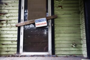 Old house with Foreclosure sign on the door.