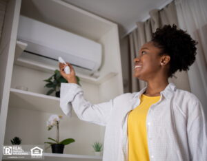 Woman turning on air conditioner with remote.