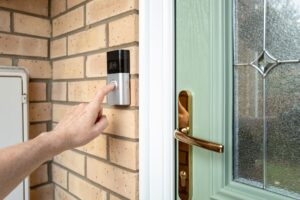 Visitor pressing the button of a wireless smart home door bell.