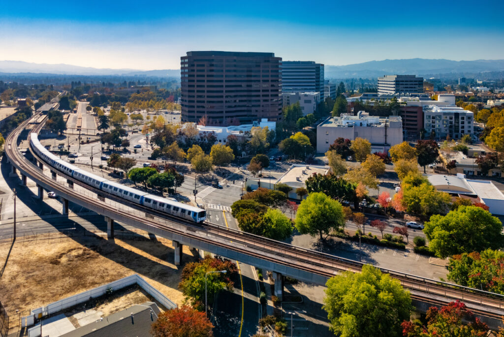 Downtown Concord skyline during autumn, with a BART Train and tracks in the foreground, and Diablo Range mountains in the background. Concord, California is part of the San Francisco Bay Area and a suburb of San Francisco.