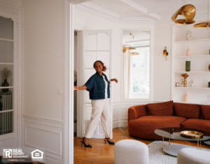 A happy tenant walks into her apartment living room.