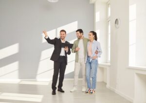 Landlord meeting with prospective tenants while reviewing rental applications in a professional office setting.