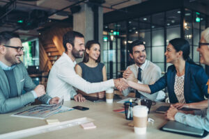 Group of property managers handshake in the office to celebrate opening 