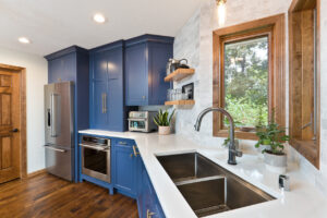 Contemporary blue kitchen with renovated windows, cabinets, and countertops.
