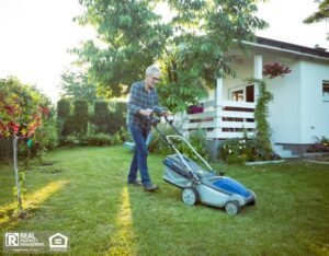 A resident mowing their lawn on a sunny day.