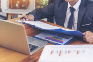 Closeup of investor working at a laptop researching real estate terms. 