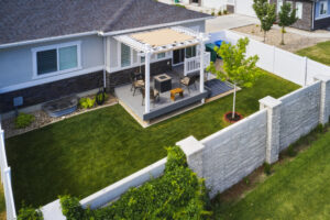 A cozy backyard featuring a patio area surrounded by a wooden fence, perfect for outdoor relaxation.
