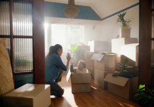 Son and mother high five in new home with boxes.