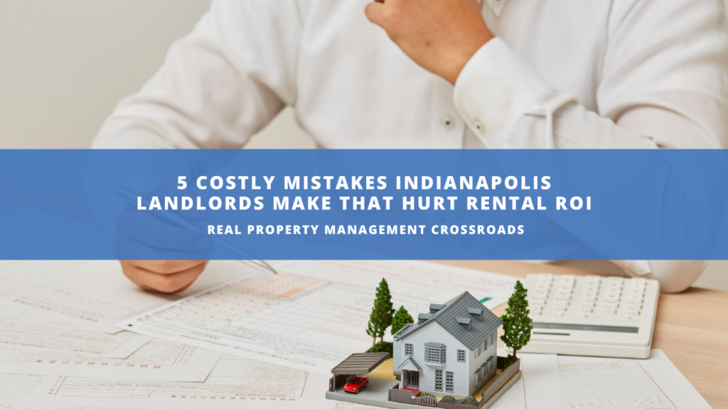 person that has papers and calculator spread out with a miniature version of a house in front of them