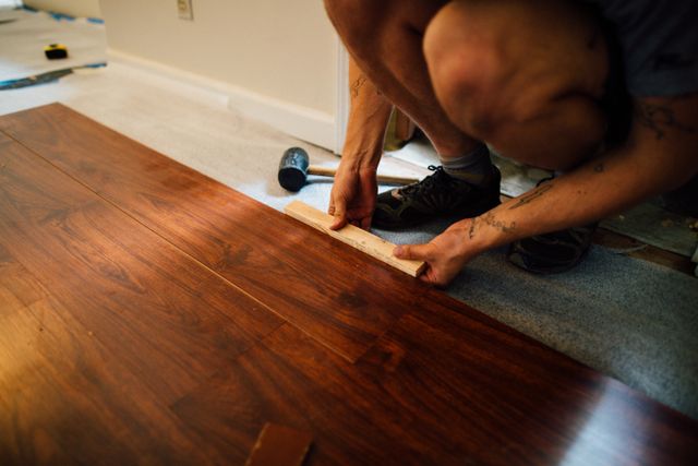 person laying wooden flooring