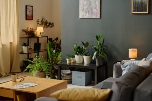 A cozy living room featuring a couch, a table, and vibrant green plants.