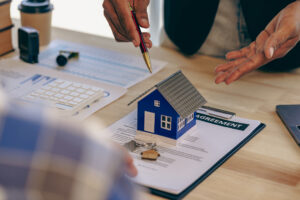 An agent shows a client a house model and goes over the terms of the lease agreement.