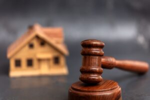 Model house and gavel on a table.