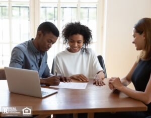 Happy young couple signs a document to finalize their agreement with a property manager.