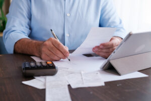 Person sitting at a desk calculating real estate costs.