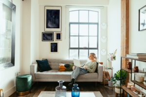 A rental property tenant sits comfortably on a couch in a stylish living room.
