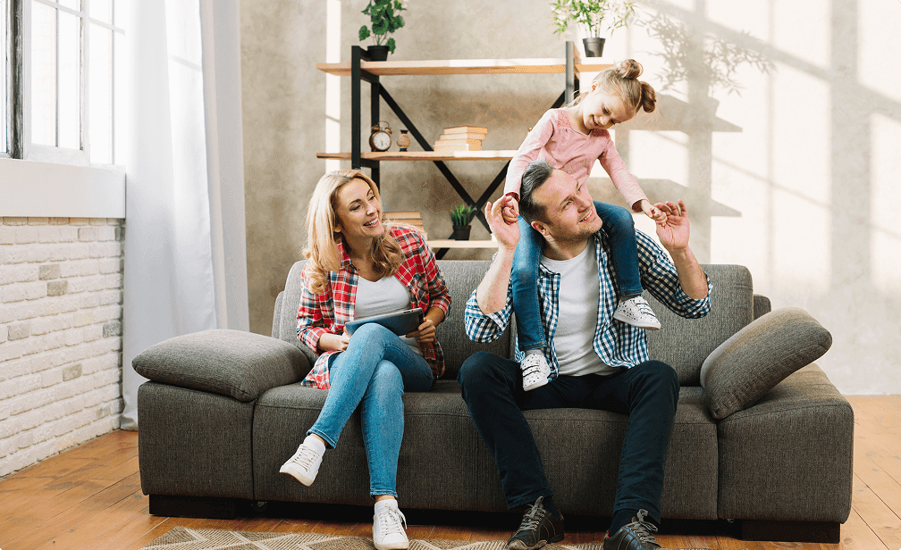A happy family with a small child sitting on a couch