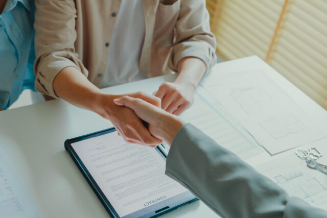 Close-up of Asian tenants sign house agreements on tablet and give them to female real estate agent after showing new houses. Landlord selling real estate to customers for investment.