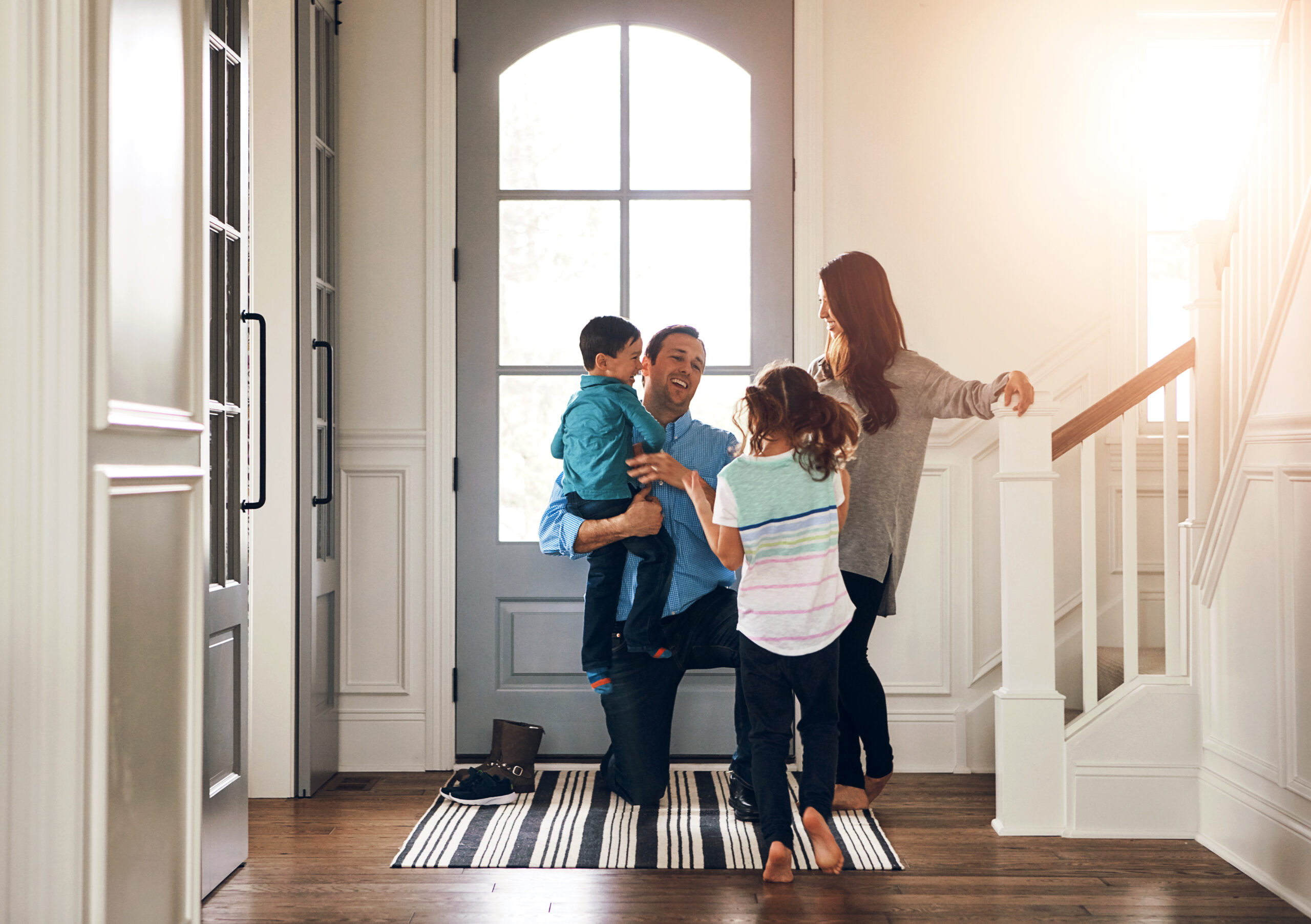Happy, door and parents with children hug in home for greeting, welcome and bonding. Family, hello and mother, father and kids in house embrace for affection, relationship and excited for return