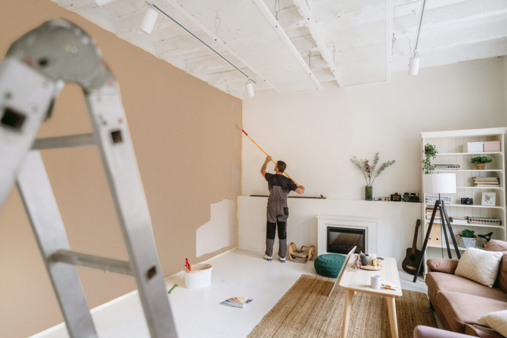 Man painting living room wall during apartment renovation