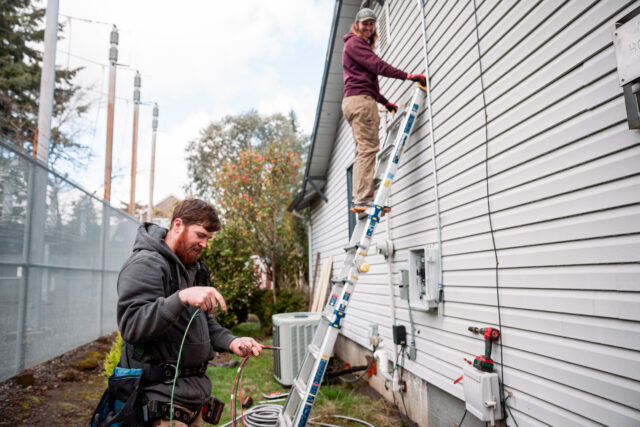 Electrician Wiring Up Solar Panel System on Home Electrician Wiring Up Solar Panel System on Home