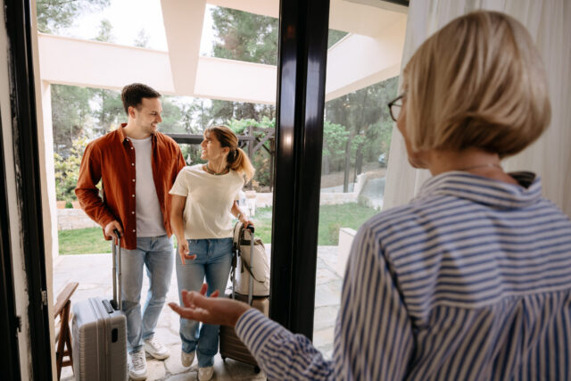 Mature real estate agent showing house to young couple