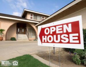 An "Open House" sign is displayed in front of a charming house, signaling an event for potential buyers.