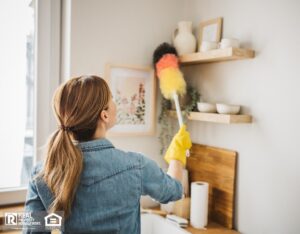 Resident dusting a surface at rental home kitchen.