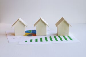 three miniature wooden houses on top of graphs