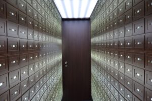 Wooden lockboxes line the walls of a modern, secure vault with a central wooden door