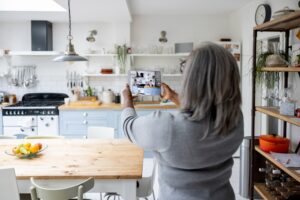 Woman taking pictures and video of rental house using a tablet computer.