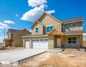 A partially built house with wooden framing and scaffolding, showcasing construction progress and tools on site.