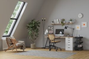 Modern cozy home office with desk, computer, armchair and indoor plants under skylight windows.