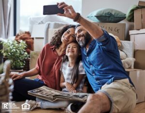 A joyful family captures a selfie while surrounded by boxes during their exciting moving day, celebrating new beginnings.