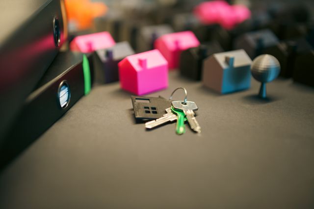 miniature houses and house keys on a desk