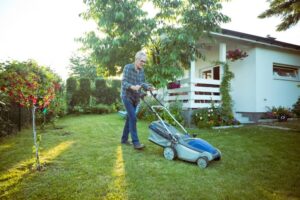 A resident mowing their lawn on a sunny day.