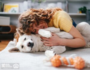 A woman enjoying quality time with her dog, showing affection while lying in a comfortable rental home.