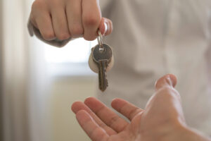 Close-up of a hand placing a set of house keys in another person's hand.