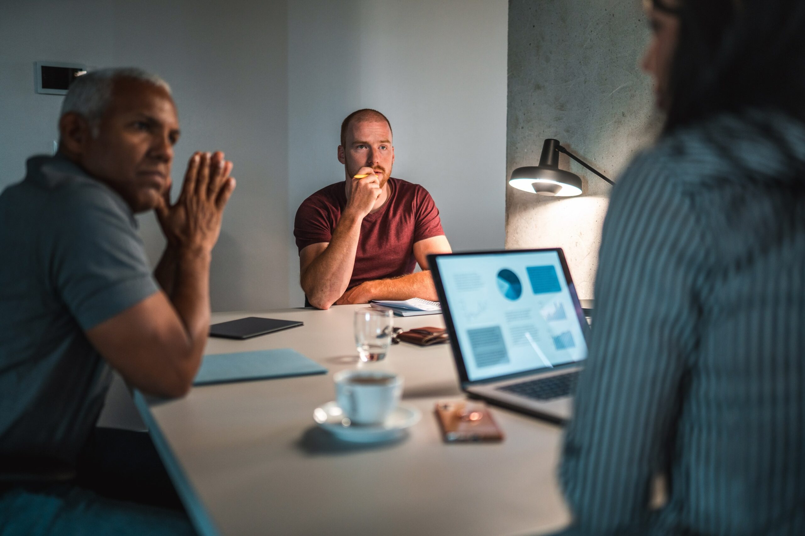 Three individuals are working at a table with laptops, diving into property management data and seeking insights on enhancing value.