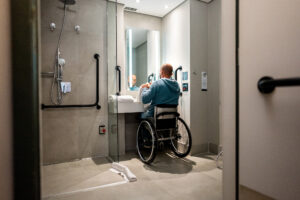 Mature wheelchair man drying his hands in the bathroom