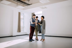 Real estate agent showing property plans to a couple of young investors. 