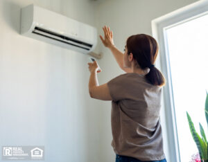Woman turning on air conditioner.
