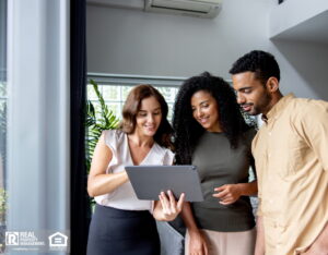 Happy group of people at a real estate showing looking at a digital tablet for details on a rental property.