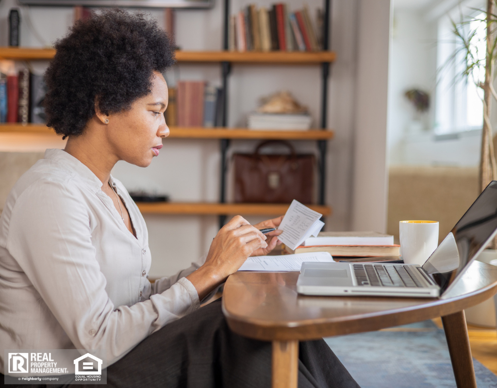 Adult woman paying bills in her home.