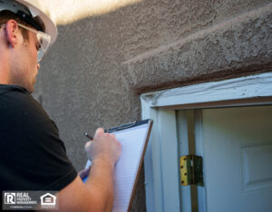 Inspector examining, taking notes and photographing an outdoor door jamb.
