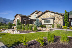 View of property and landscape with green grass and house. 